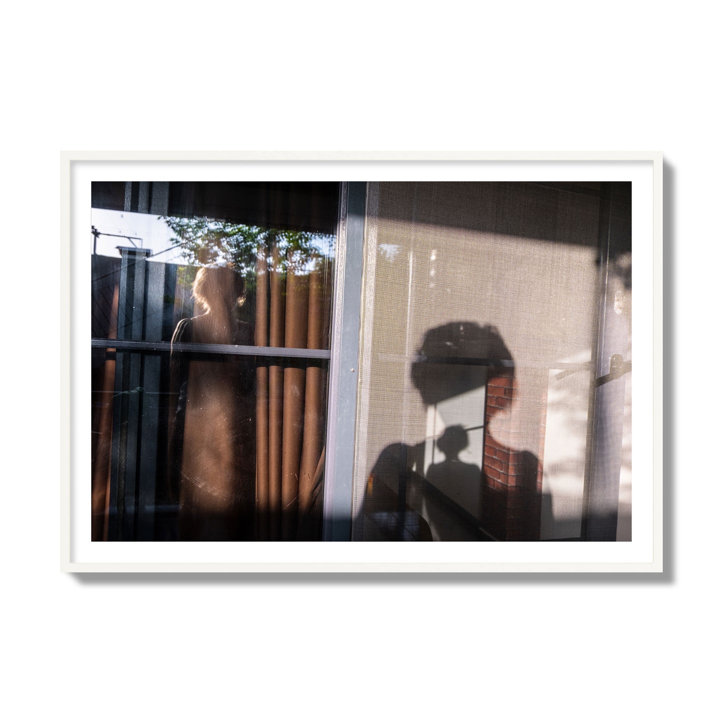 Fine art photograph of a person's silhouette against a window with curtains, archival pigment print, collector size, white frame.