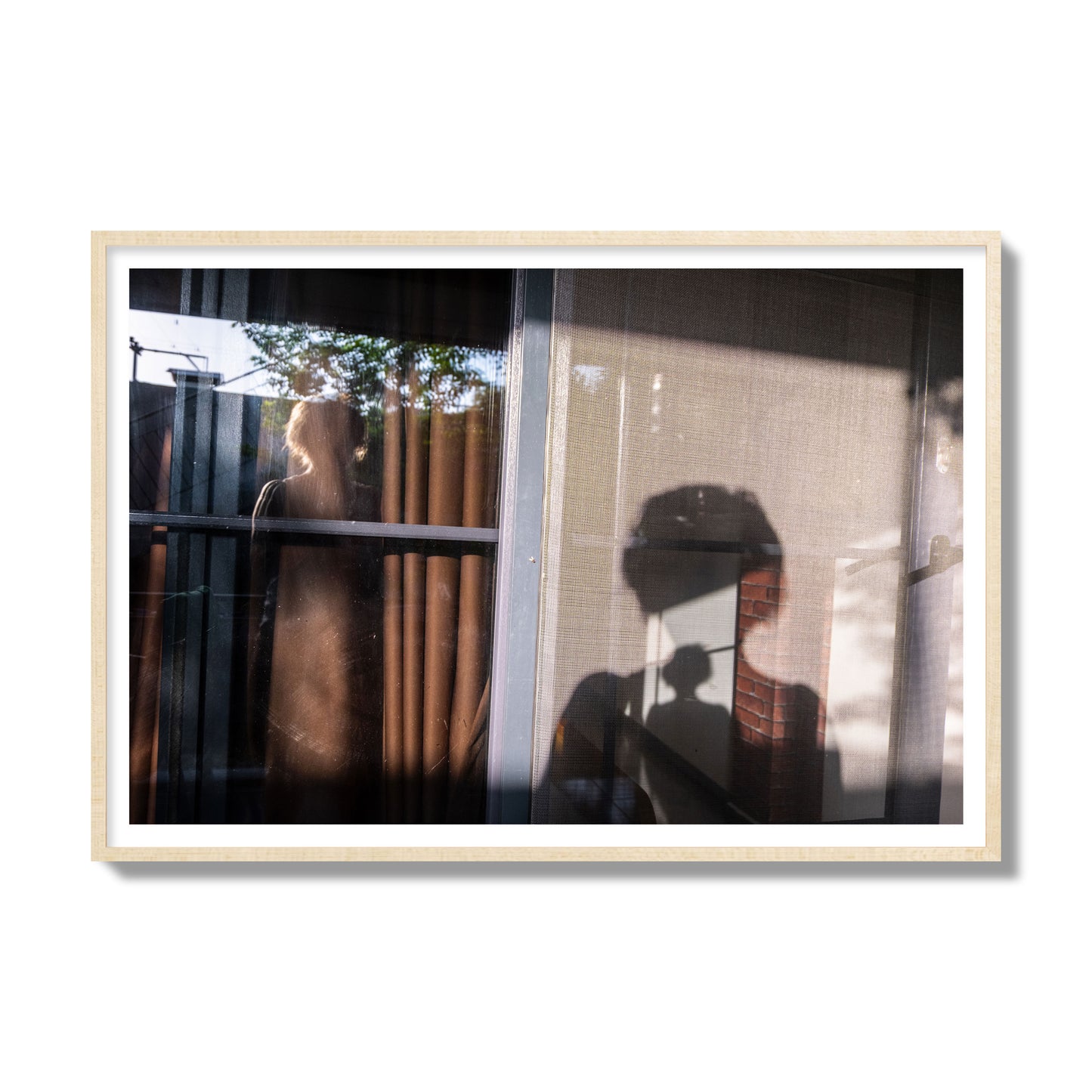 Fine art photograph of a person's silhouette against a window with curtains, archival pigment print, gallery size, natural wood frame.