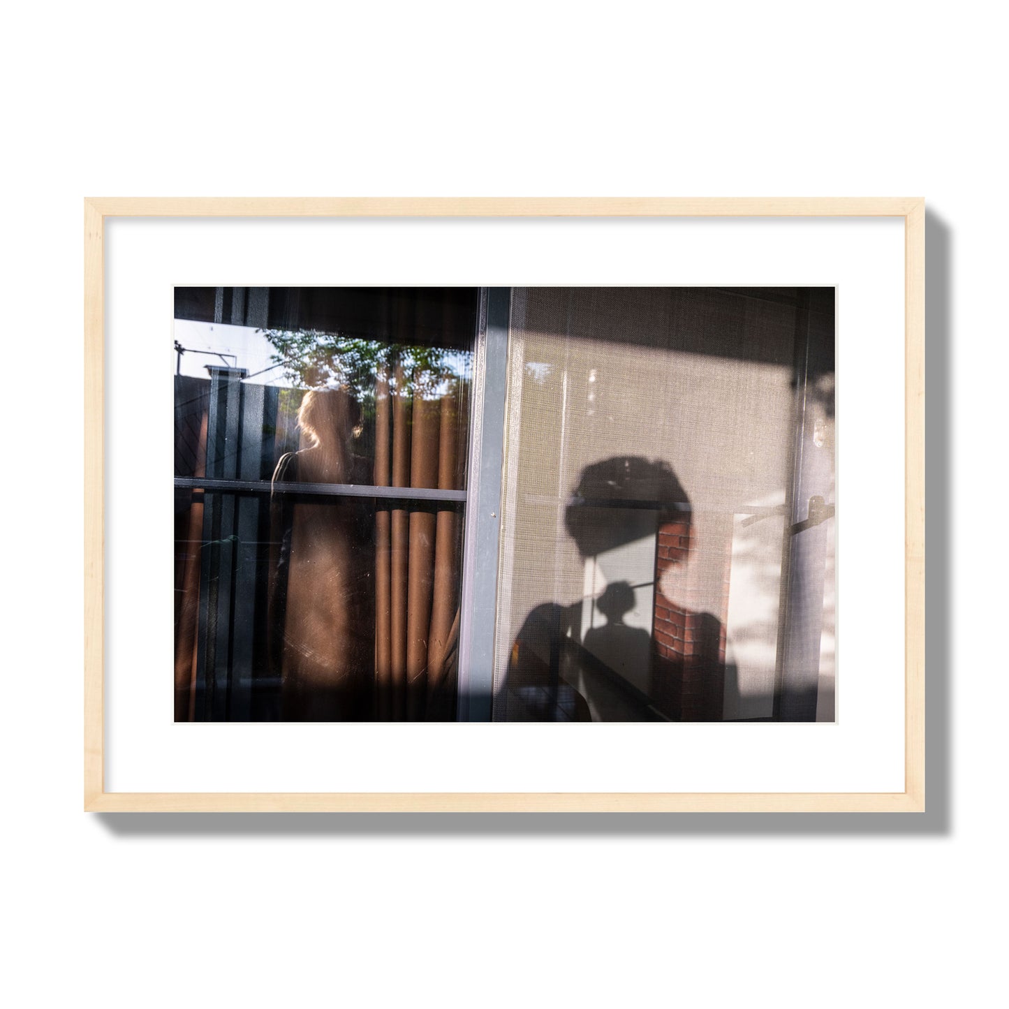 Fine art photograph of a person's silhouette against a window with curtains, archival pigment print, large size, natural wood frame.