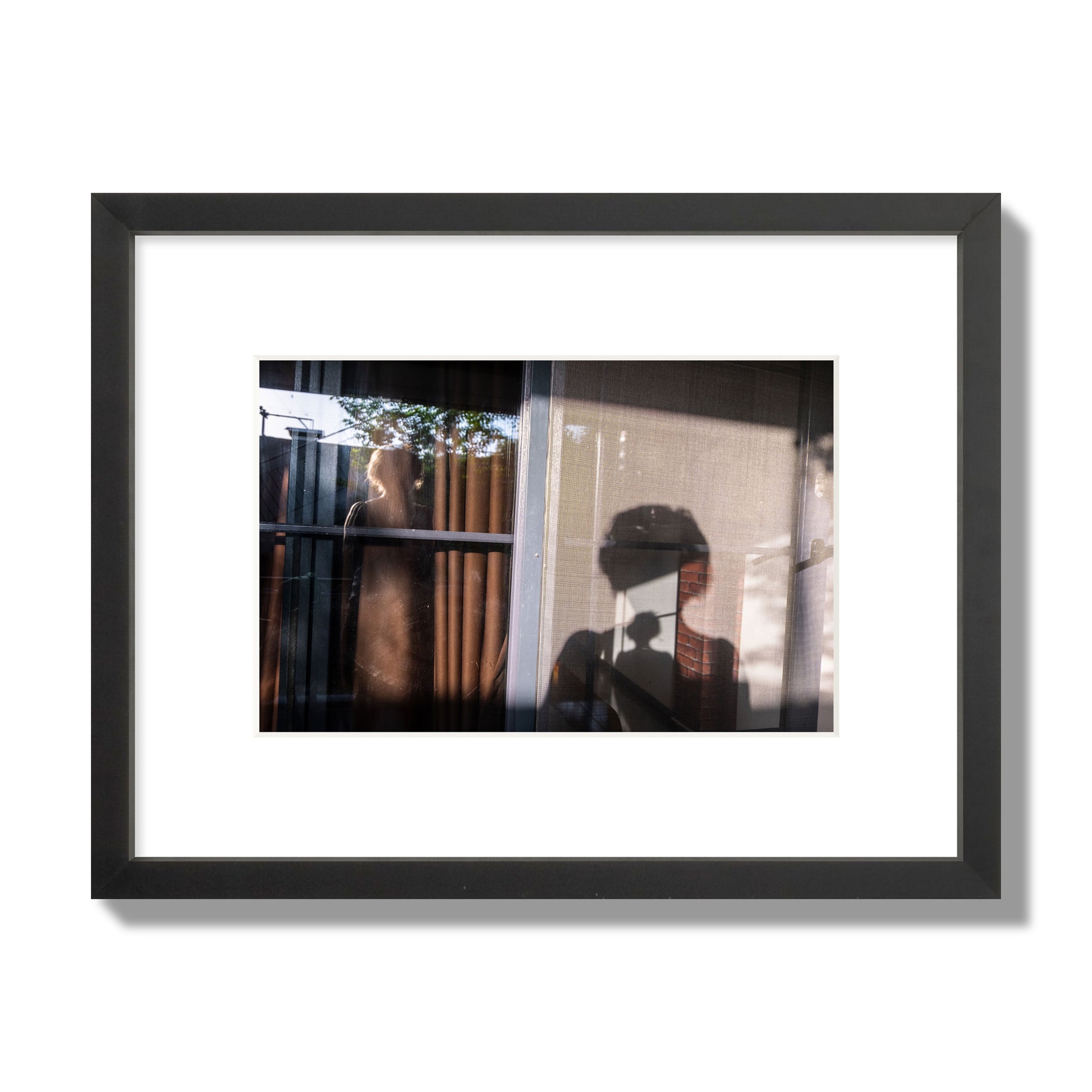 Fine art photograph of a person's silhouette against a window with curtains, archival pigment print, small size, black frame.