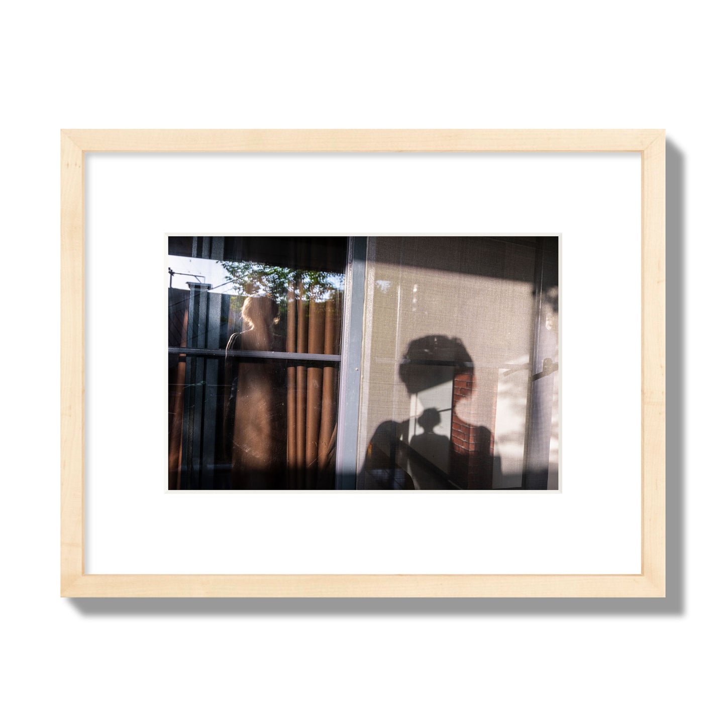 Fine art photograph of a person's silhouette against a window with curtains, archival pigment print, small size, natural wood frame.