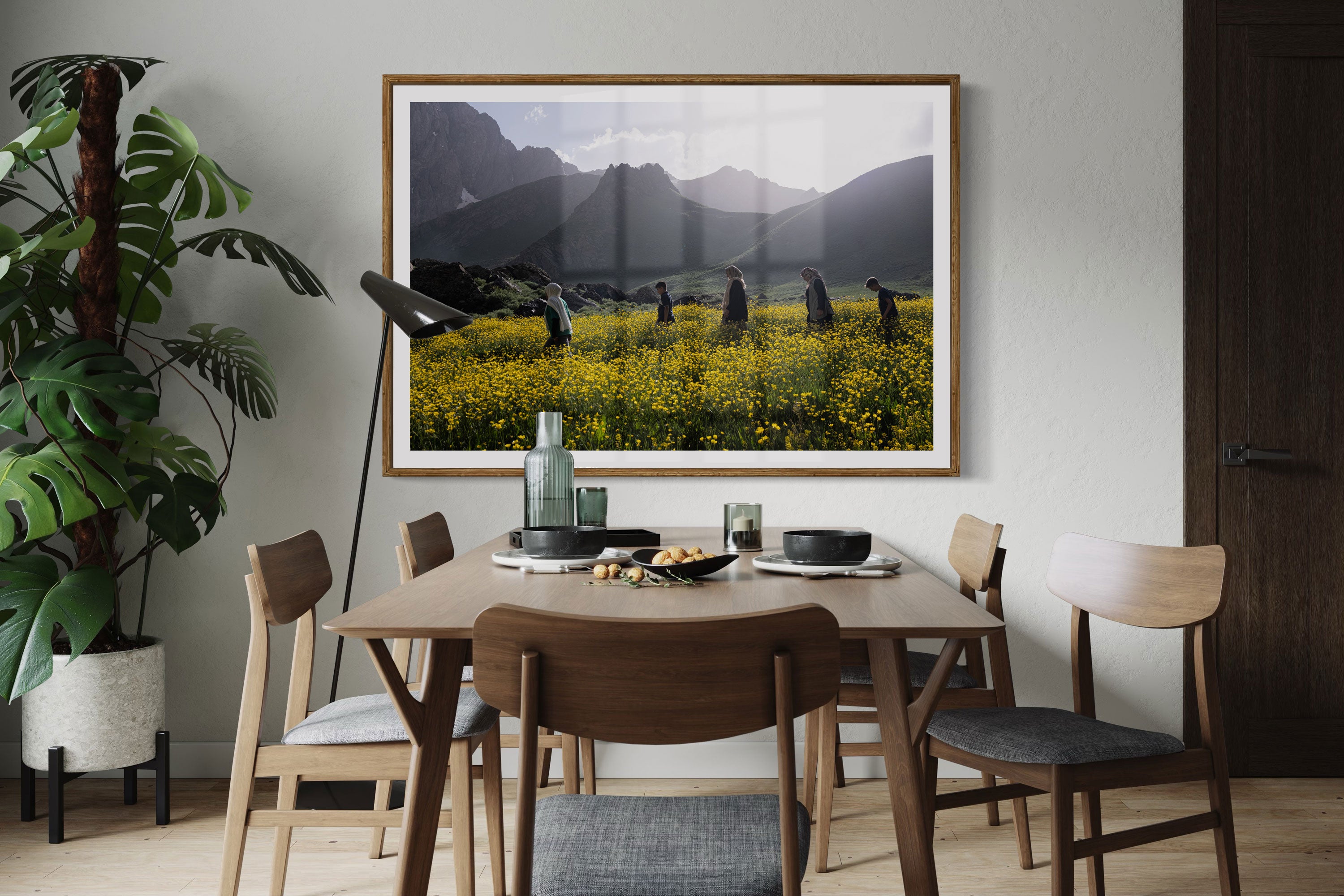 A contemporary dining room with a fine art framed photo of a group of people walking through a field of flowers at the foot of the Cilo Mountains.