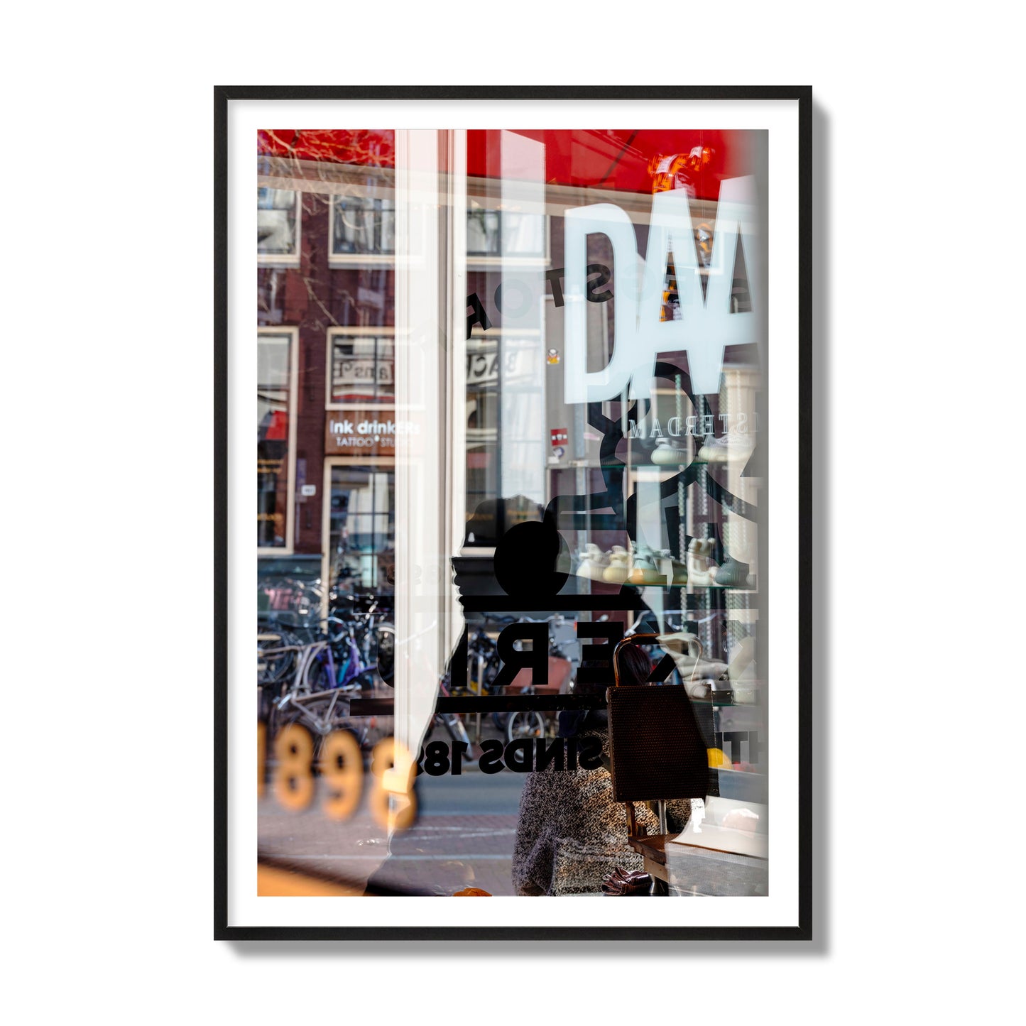 Fine art street photograph of a busy Amsterdam street scene with reflections, silhouettes, shoppers, and store signs. Archival pigment print, collector size, black frame.