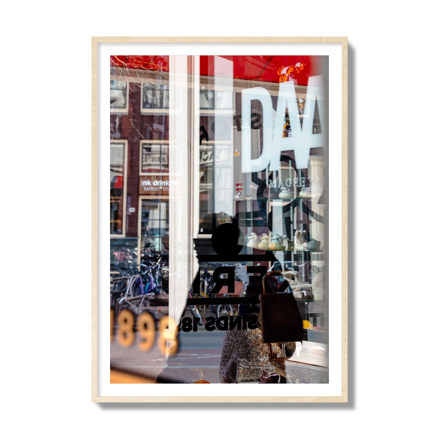 Fine art street photograph of a busy Amsterdam street scene with reflections, silhouettes, shoppers, and store signs. Archival pigment print, collector size, natural wood frame.