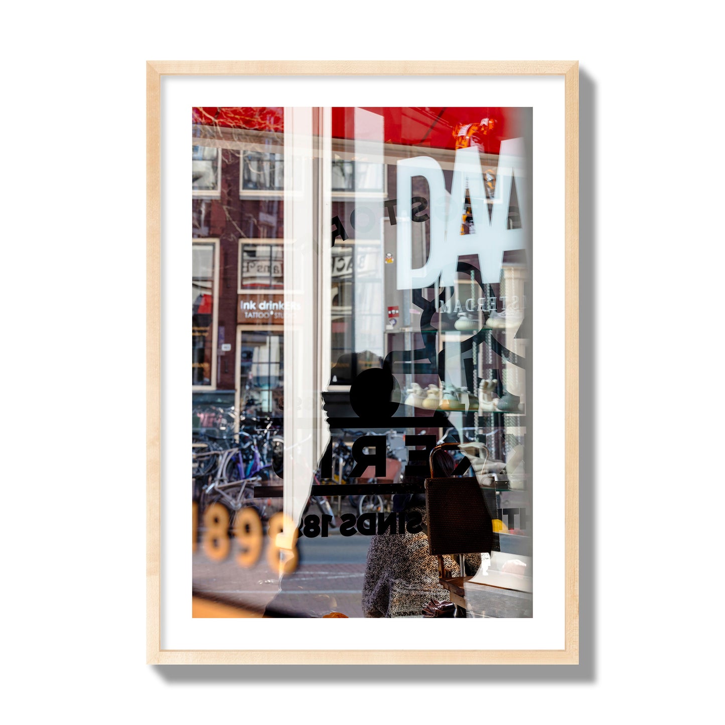Fine art street photograph of a busy Amsterdam street scene with reflections, silhouettes, shoppers, and store signs. Archival pigment print, giant size, natural wood frame.