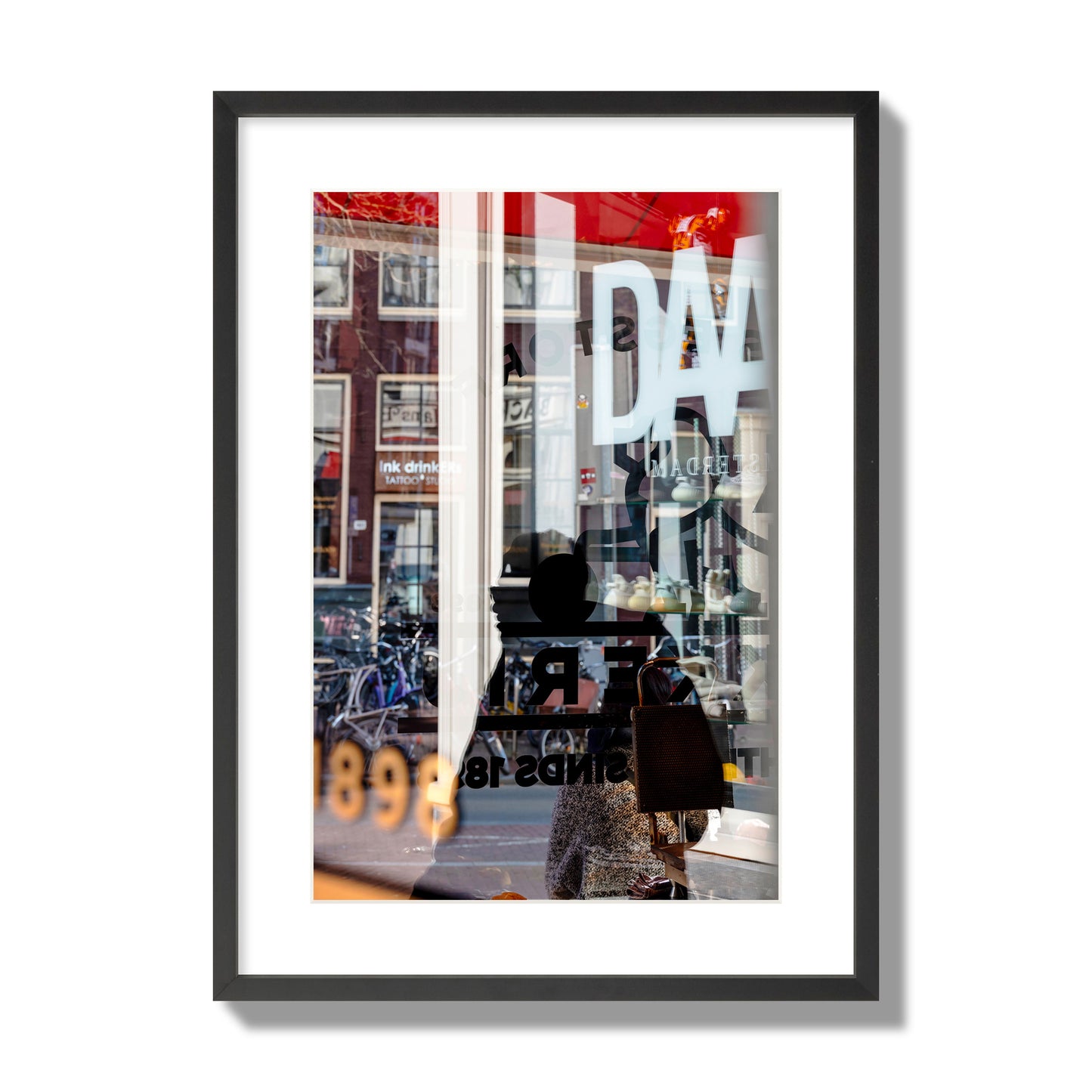 Fine art street photograph of a busy Amsterdam street scene with reflections, silhouettes, shoppers, and store signs. Archival pigment print, large size, black frame.