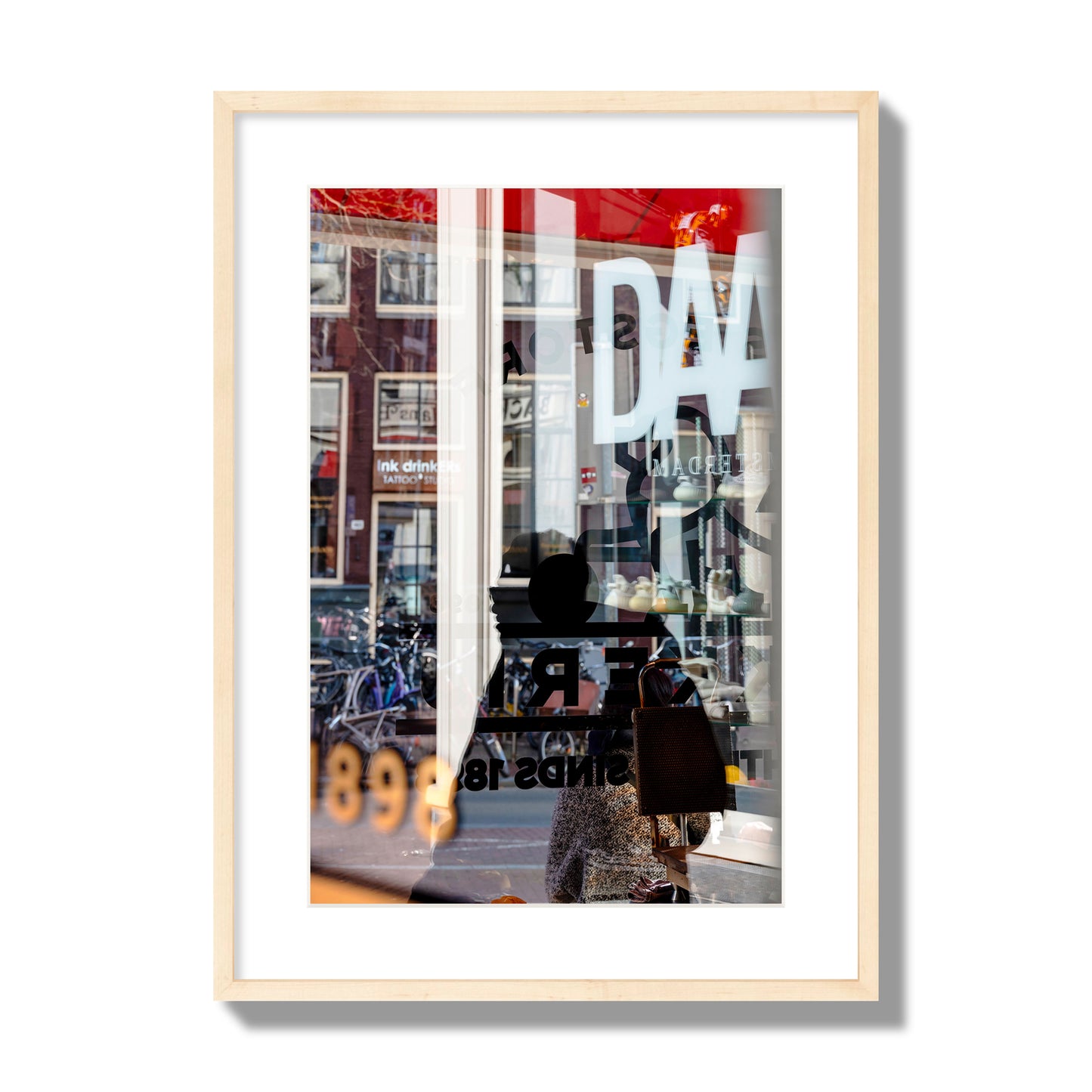 Fine art street photograph of a busy Amsterdam street scene with reflections, silhouettes, shoppers, and store signs. Archival pigment print, large size, natural wood frame.