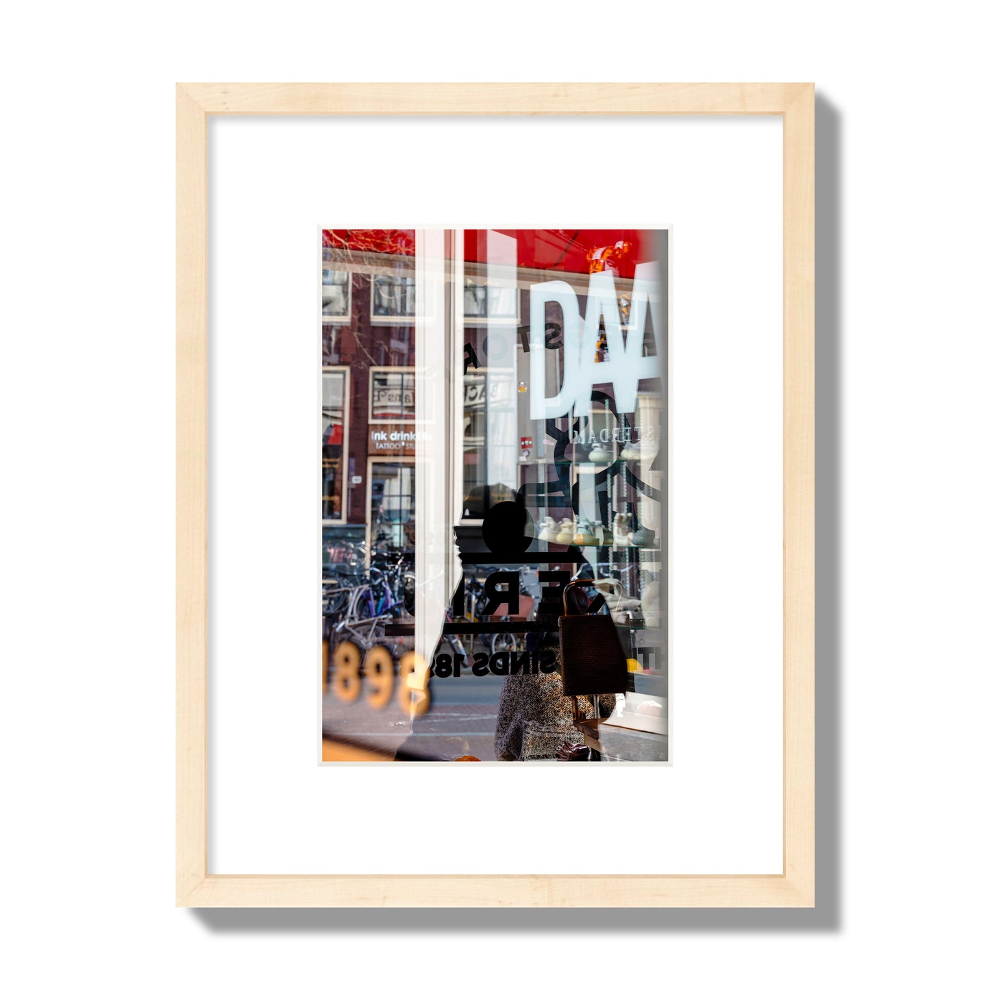 Fine art street photograph of a busy Amsterdam street scene with reflections, silhouettes, shoppers, and store signs. Archival pigment print, small size, natural wood frame.