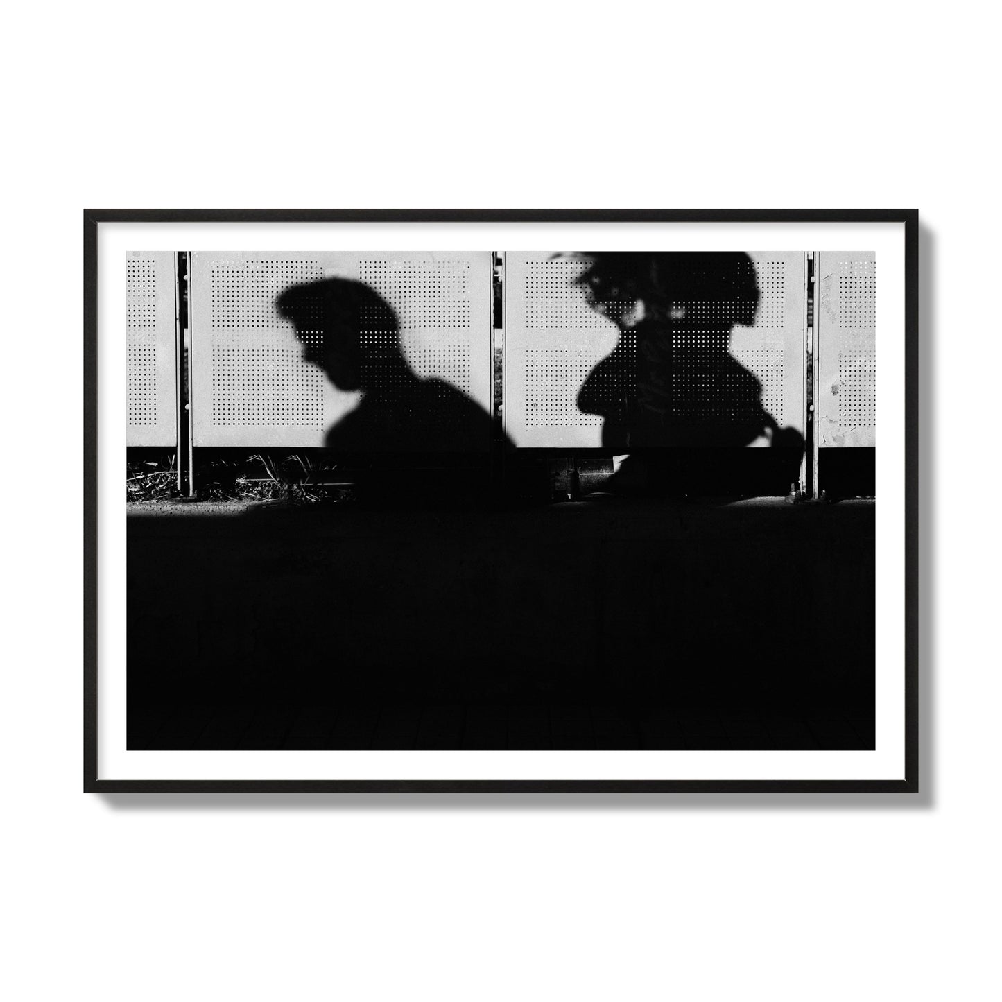 Fine art black and white street photography capturing the silhouettes of two individuals against a wall in Athens Greece, archival pigment print, collector size, black frame