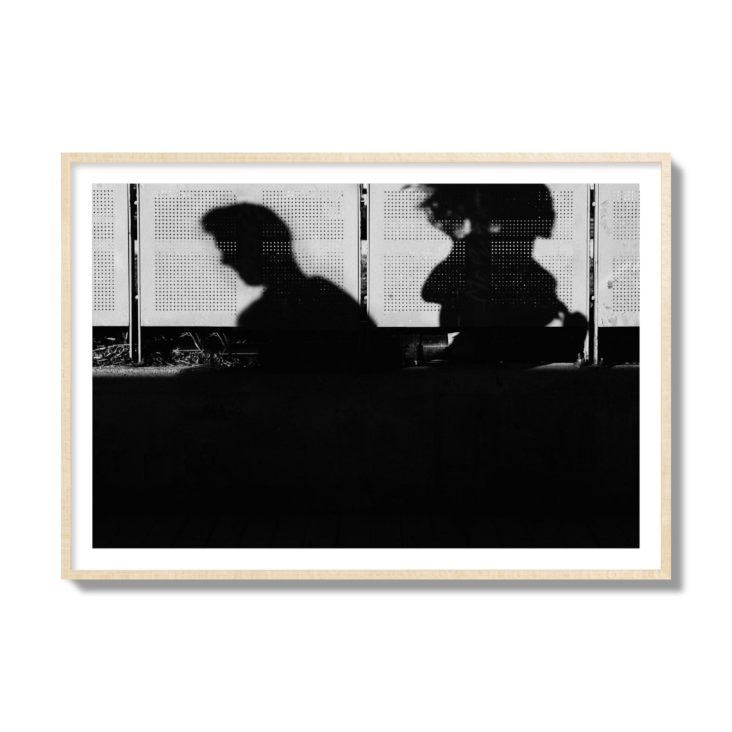 Fine art black and white street photography capturing the silhouettes of two individuals against a wall in Athens Greece, archival pigment print, collector size, natural wood frame