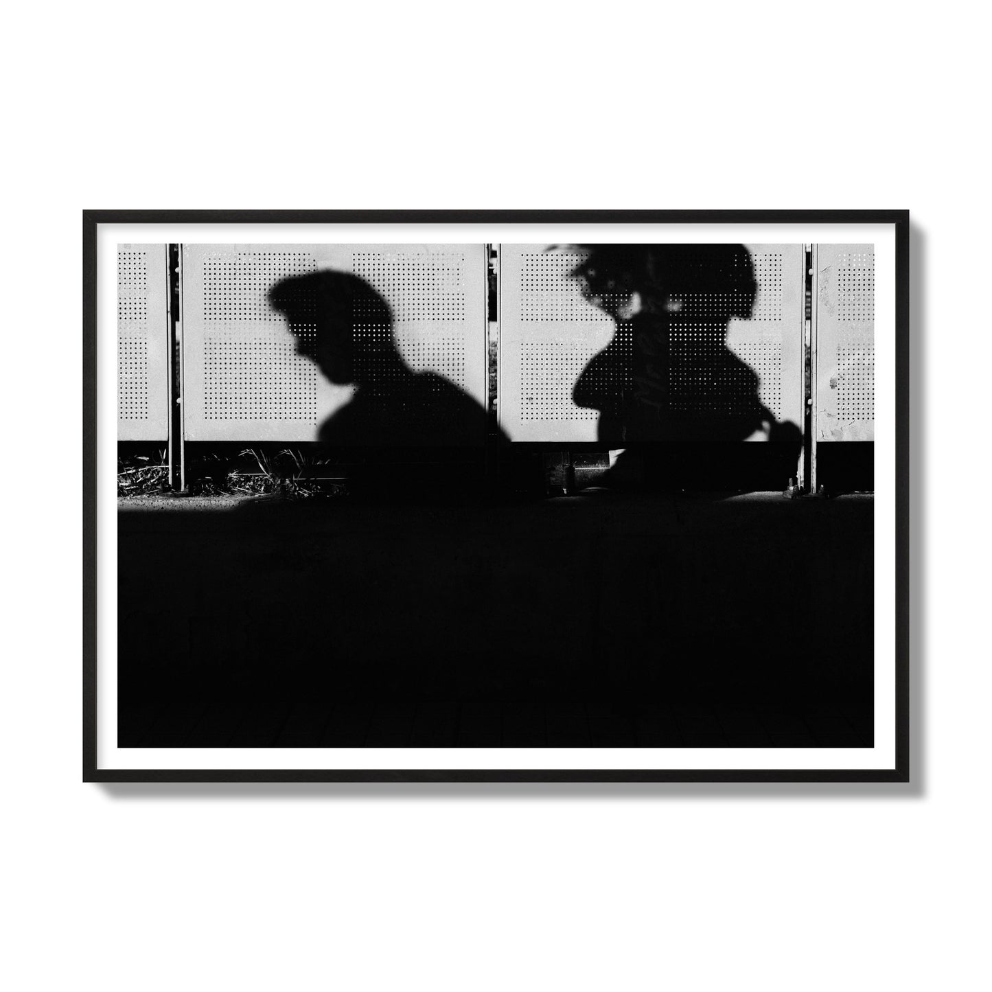Fine art black and white street photography capturing the silhouettes of two individuals against a wall in Athens Greece, archival pigment print, gallery size, black frame