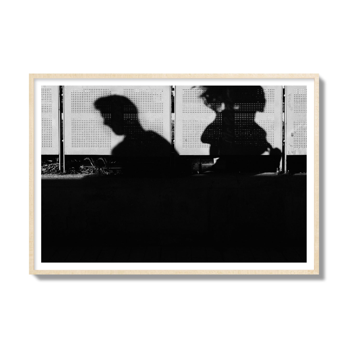 Fine art black and white street photography capturing the silhouettes of two individuals against a wall in Athens Greece, archival pigment print, gallery size, natural wood frame