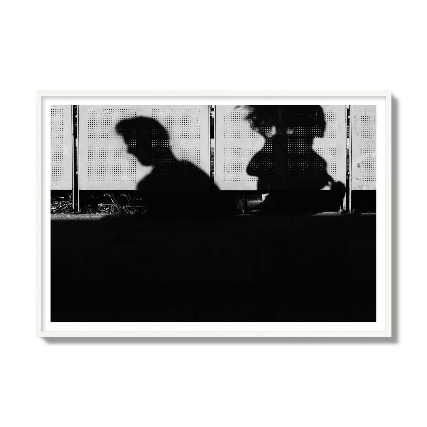 Fine art black and white street photography capturing the silhouettes of two individuals against a wall in Athens Greece, archival pigment print, gallery size, white frame