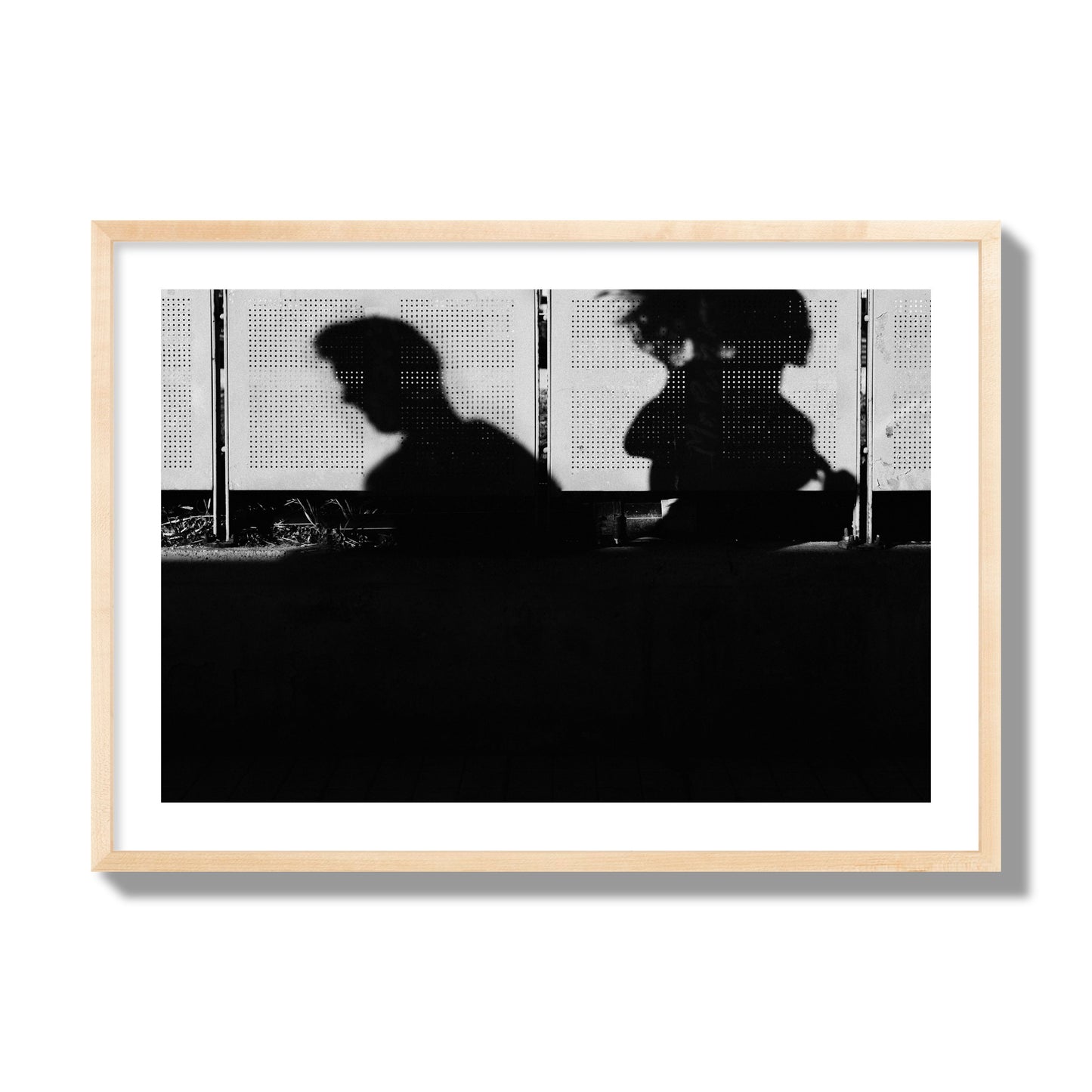 Fine art black and white street photography capturing the silhouettes of two individuals against a wall in Athens Greece, archival pigment print, giant size, natural wood frame