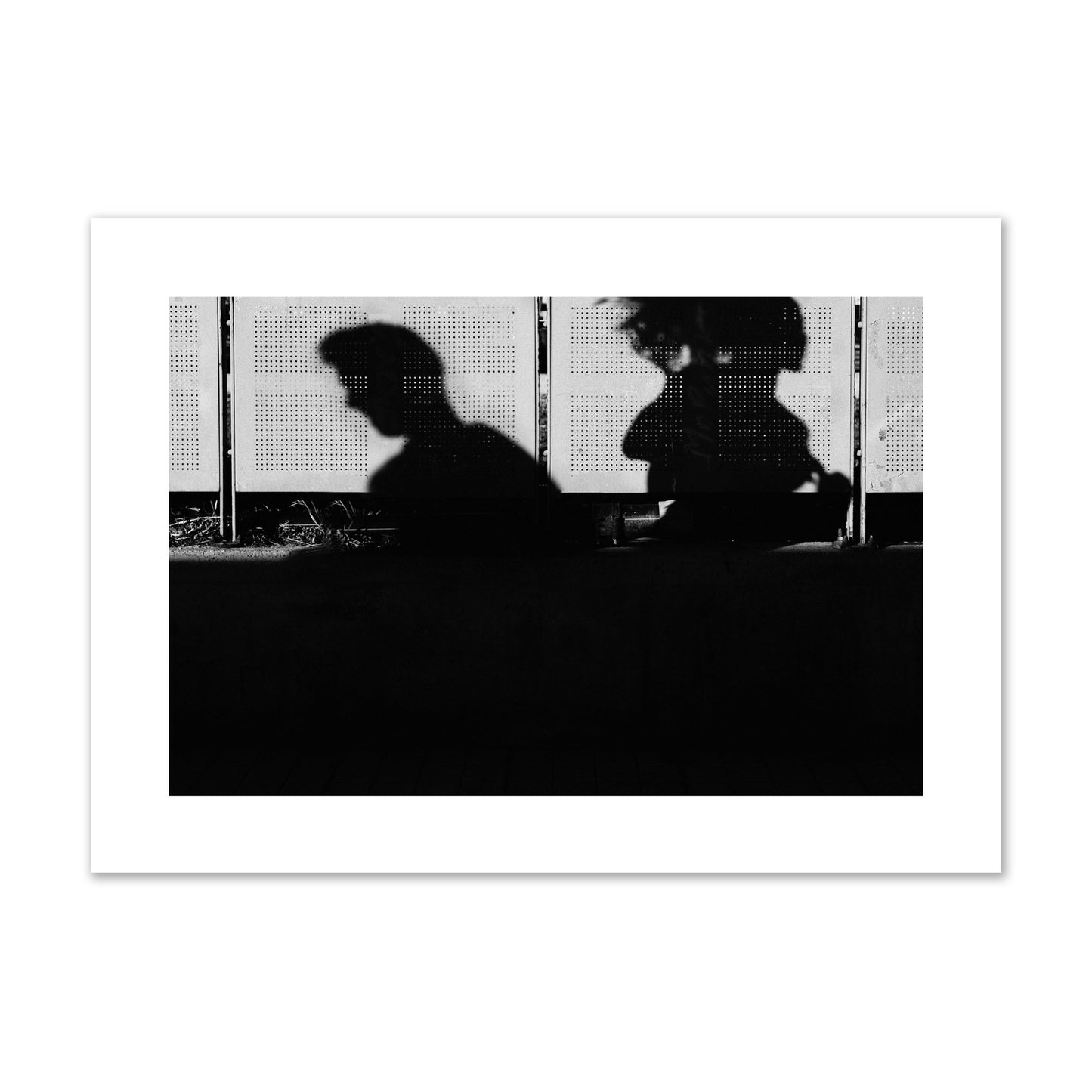 Fine art black and white street photography capturing the silhouettes of two individuals against a wall in Athens Greece, archival pigment print, giant size, unframed