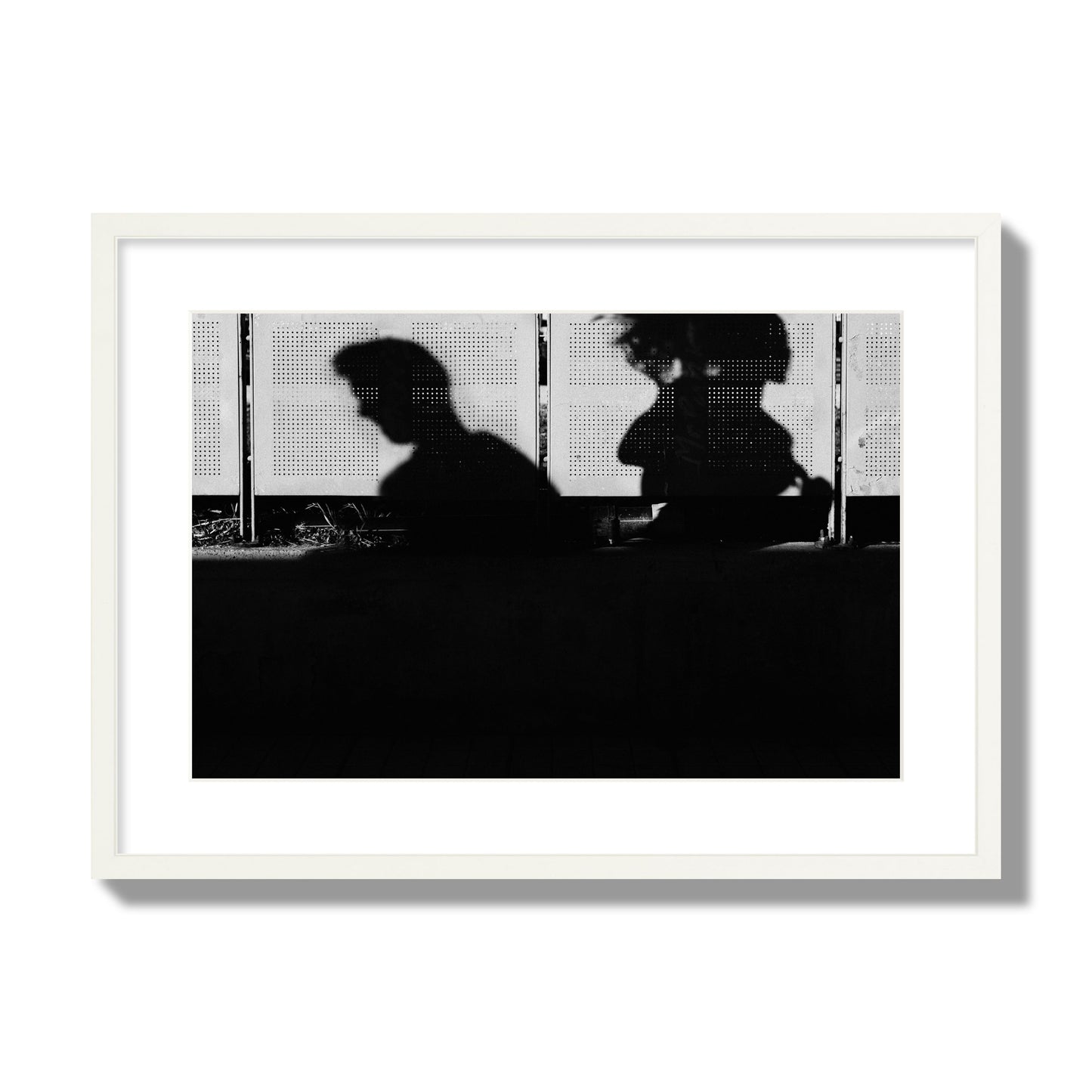 Fine art black and white street photography capturing the silhouettes of two individuals against a wall in Athens Greece, archival pigment print, large size, frame frame