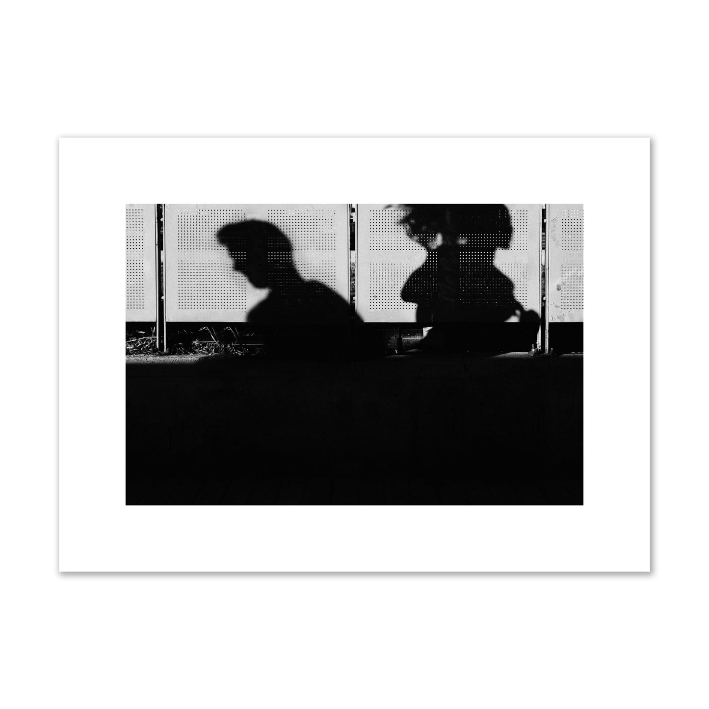 Fine art black and white street photography capturing the silhouettes of two individuals against a wall in Athens Greece, archival pigment print, medium size, unframed