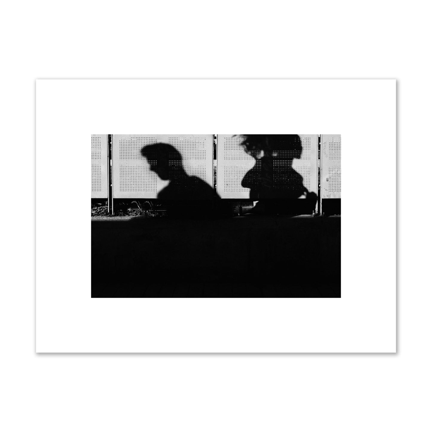 Fine art black and white street photography capturing the silhouettes of two individuals against a wall in Athens Greece, archival pigment print, small size, unframed