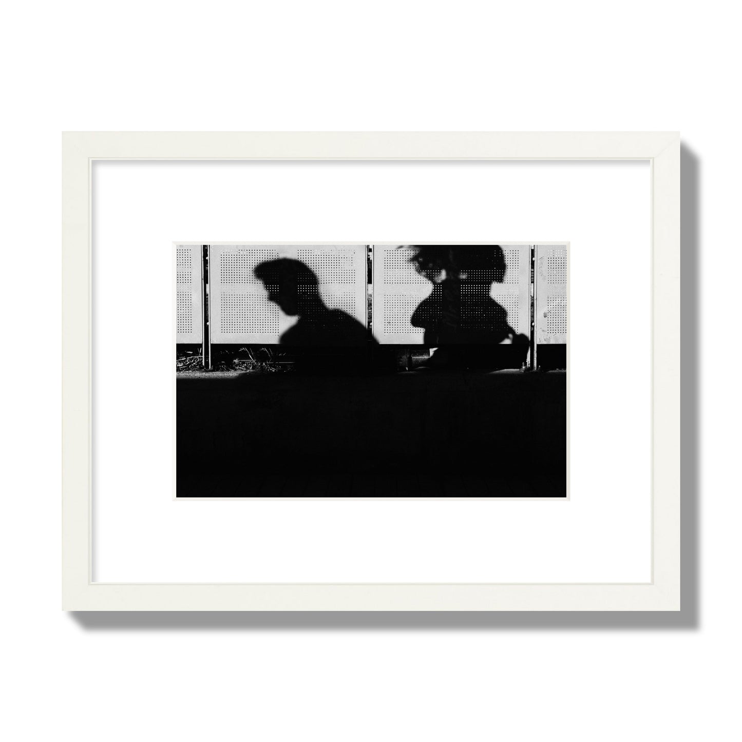 Fine art black and white street photography capturing the silhouettes of two individuals against a wall in Athens Greece, archival pigment print, small size, white frame