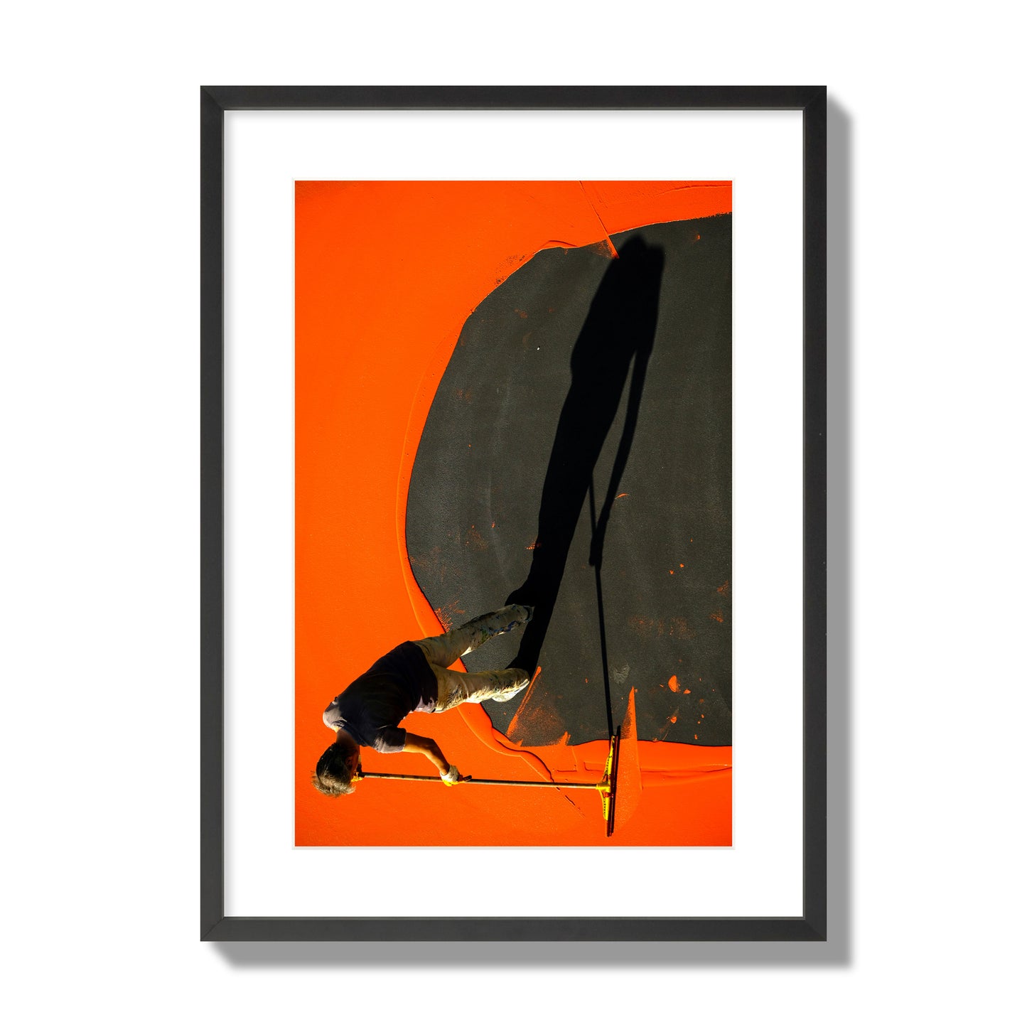 Fine art street photograph, overhead view of a man painting an orange rooftop, captured in vivid detail. Archival pigment print, large size, black frame.