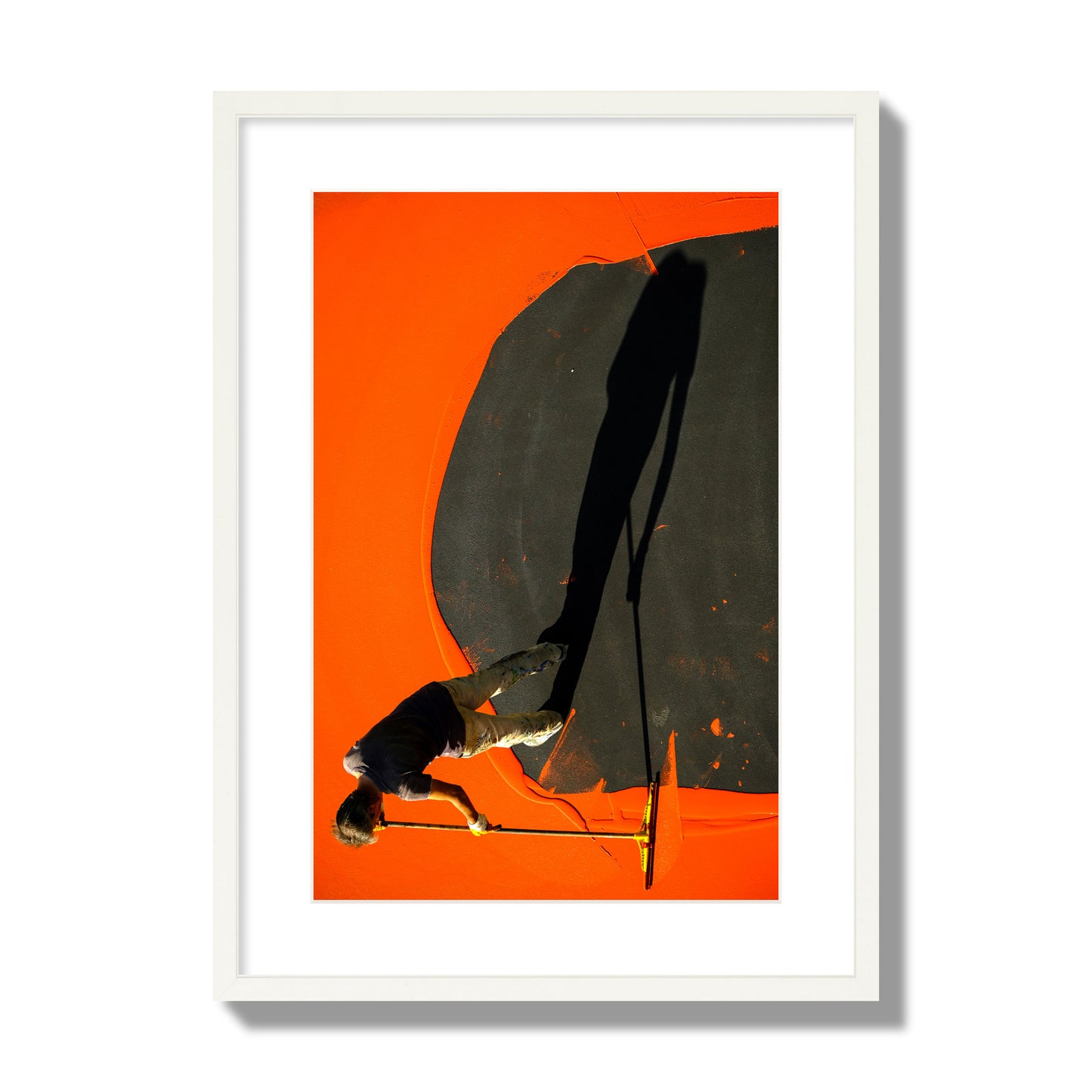 Fine art street photograph, overhead view of a man painting an orange rooftop, captured in vivid detail. Archival pigment print, large size, white frame.