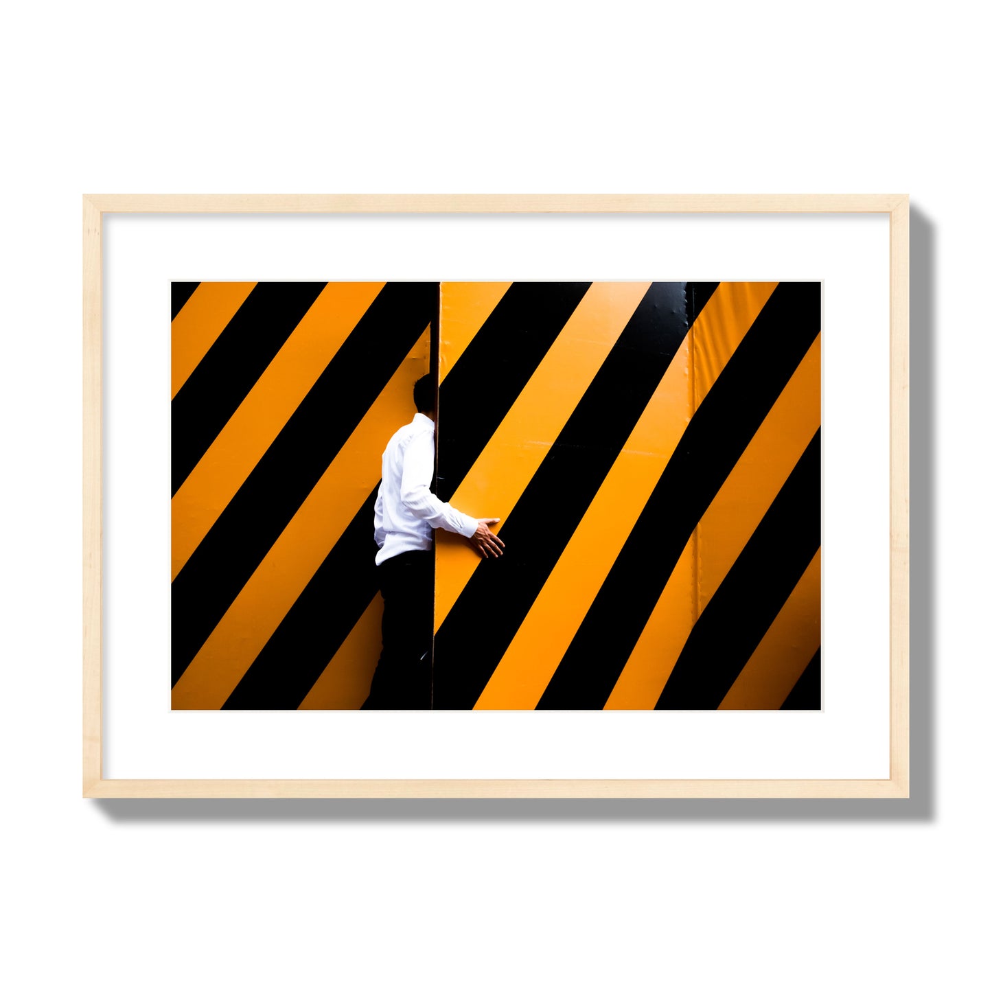 Fine art street photograph of a man opening an orange and black stripped construction door. Archival pigment print, large size, natural wood frame.