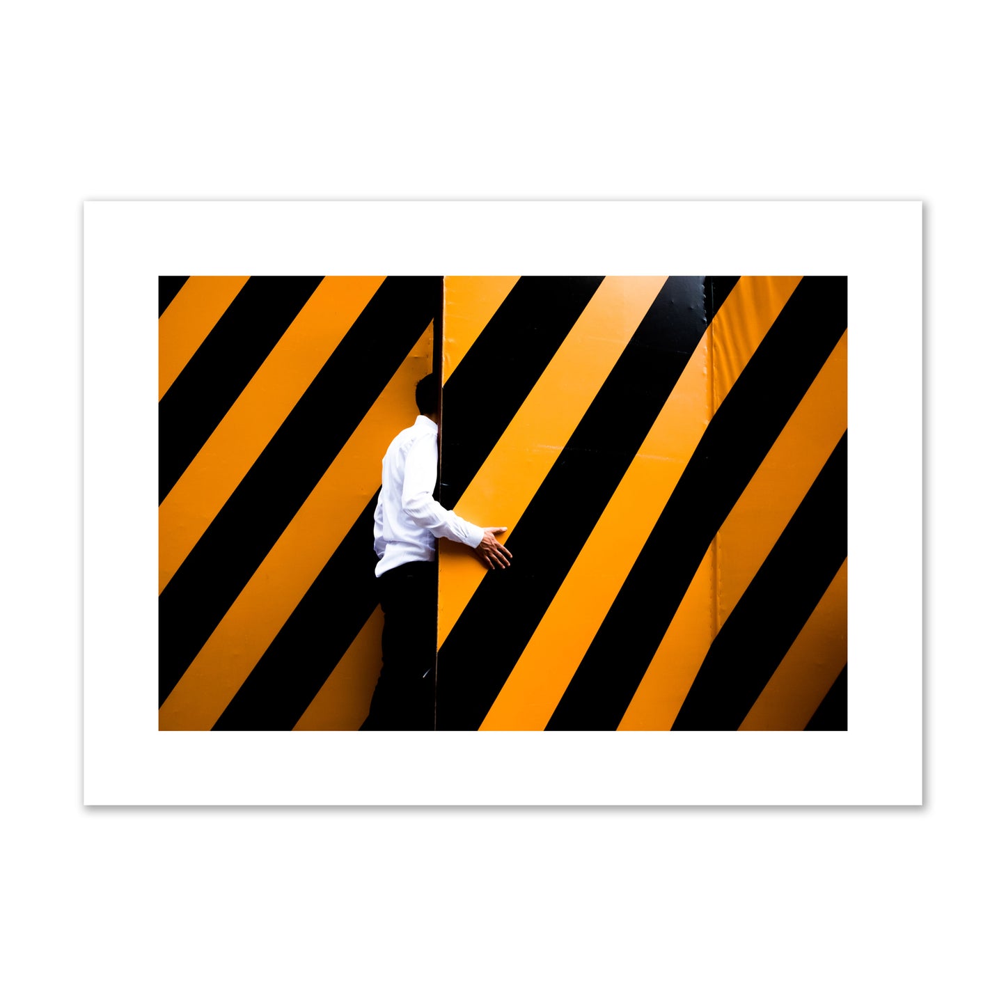 Fine art street photograph of a man opening an orange and black stripped construction door. Archival pigment print, large size, unframed.