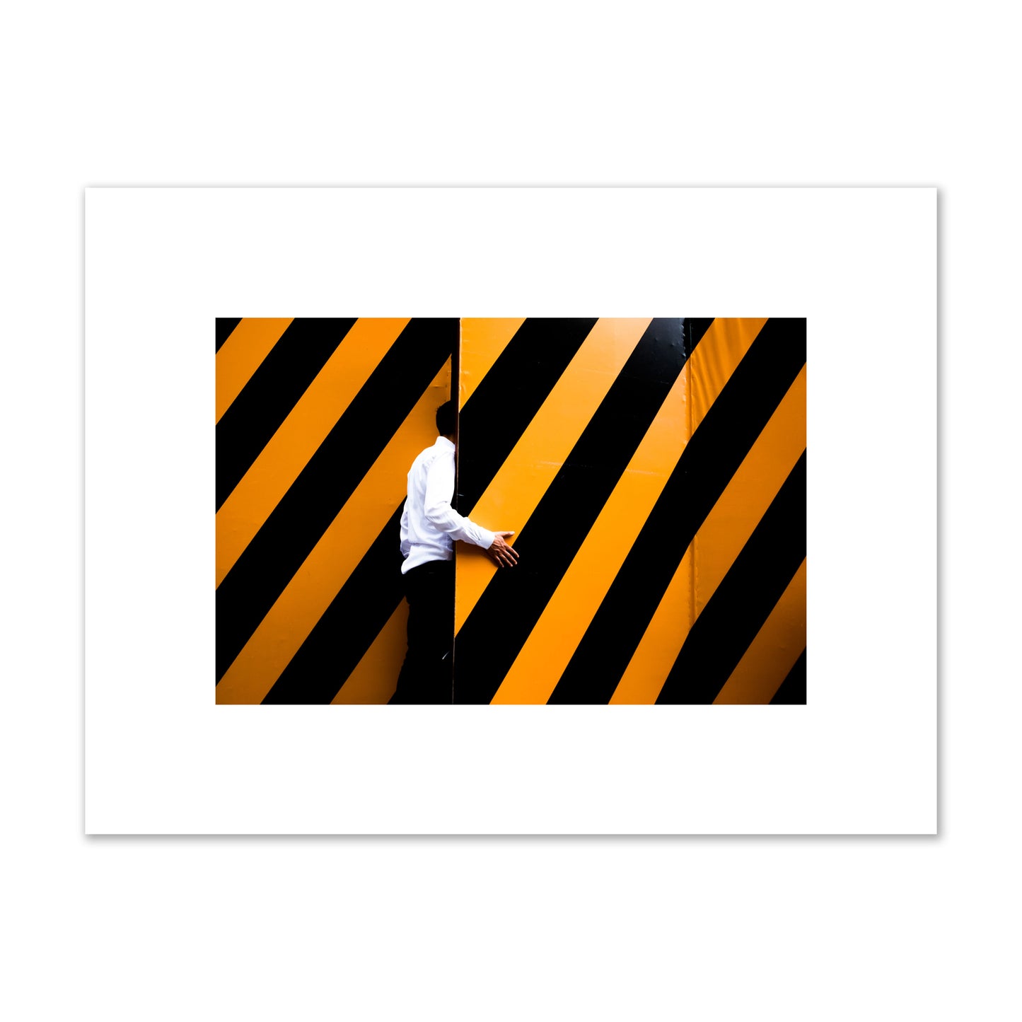 Fine art street photograph of a man opening an orange and black stripped construction door. Archival pigment print, small size, unframed.