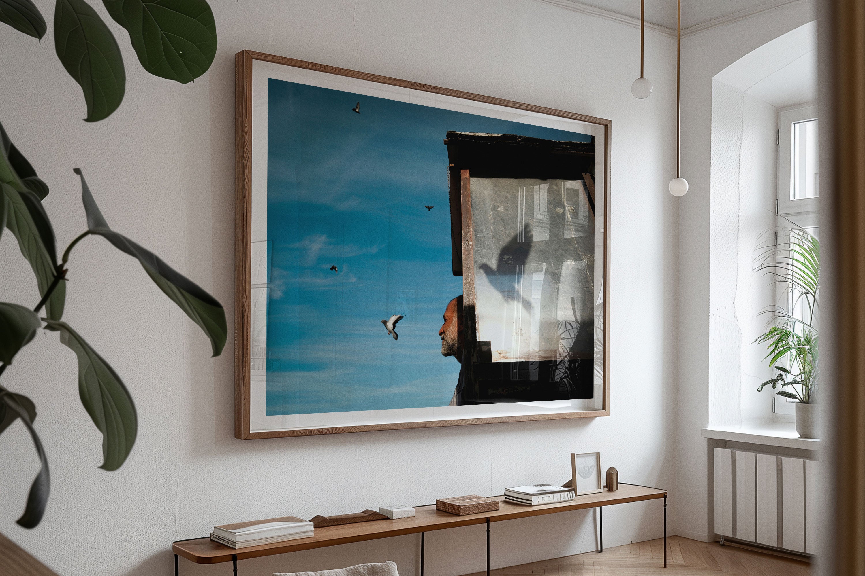Dining room with a framed fine art street photograph of a man watching a bird fly away.