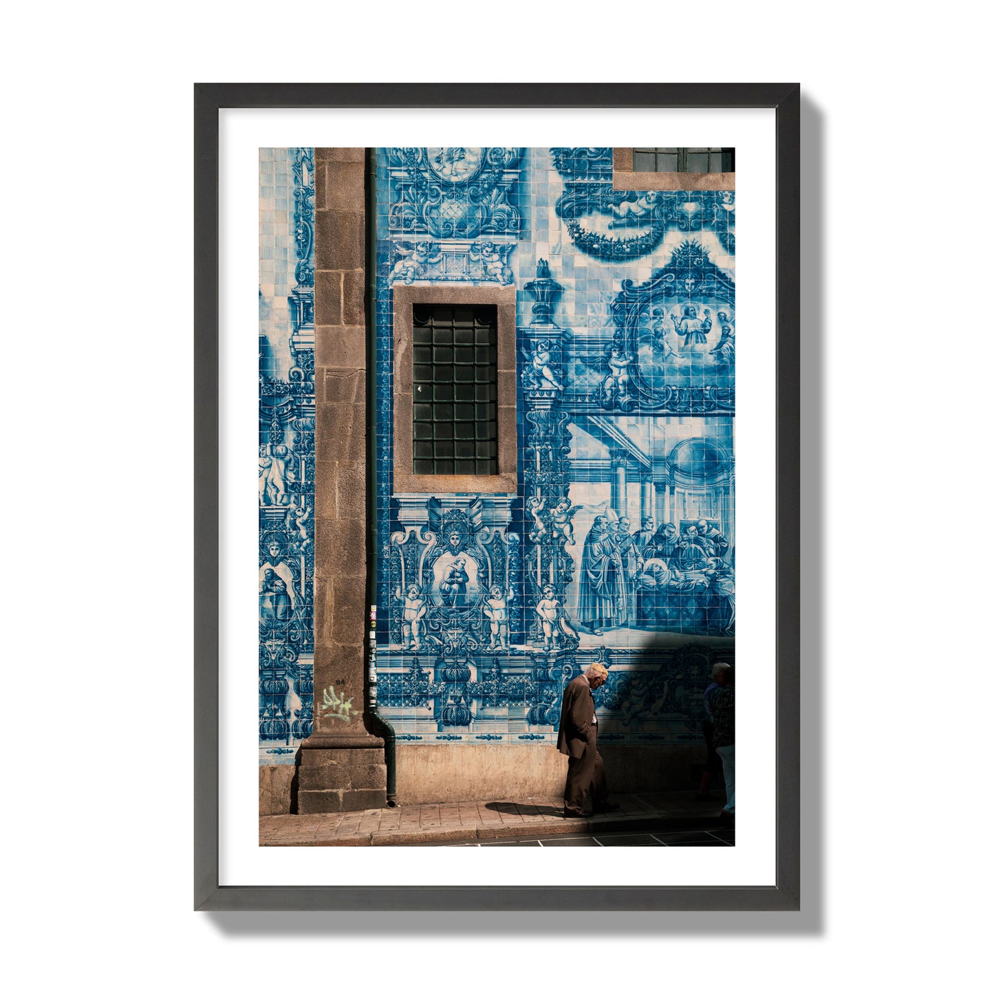 Fine art street photograph of an elderly man walking past traditional blue azulejo tile mural on a historic building in Lisbon, Portugal, archival pigment print, giant size, black frame.