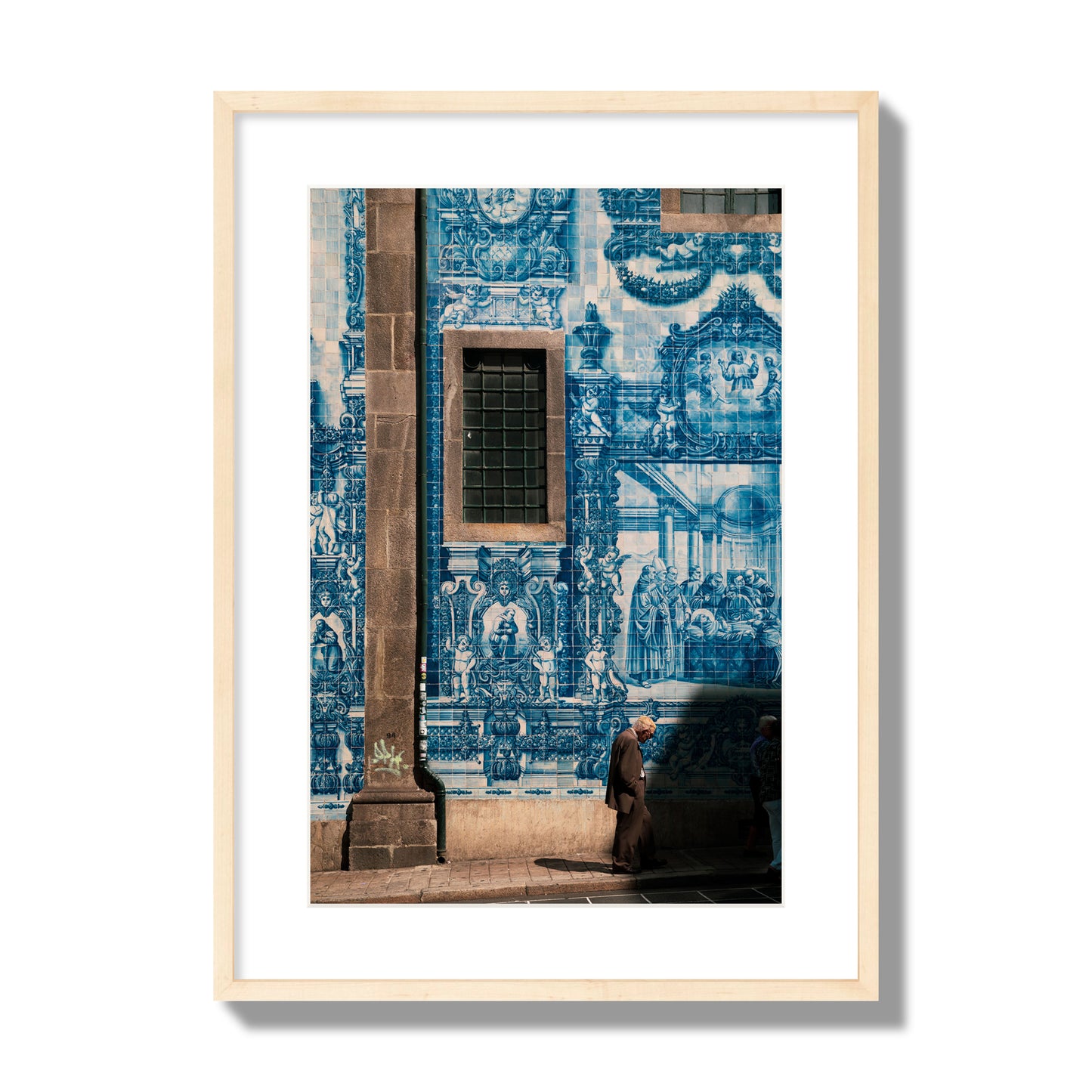 Fine art street photograph of an elderly man walking past traditional blue azulejo tile mural on a historic building in Lisbon, Portugal, archival pigment print, large size, natural wood frame.