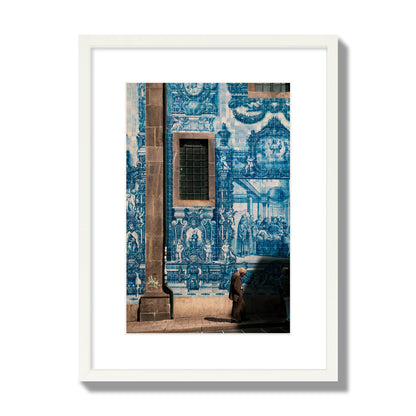 Fine art street photograph of an elderly man walking past traditional blue azulejo tile mural on a historic building in Lisbon, Portugal, archival pigment print, medium size, white frame.