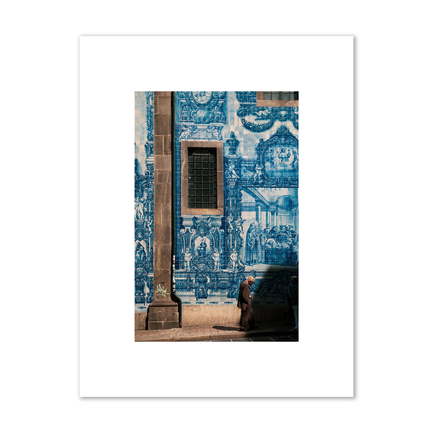 Fine art street photograph of an elderly man walking past traditional blue azulejo tile mural on a historic building in Lisbon, Portugal, archival pigment print, small size, print.