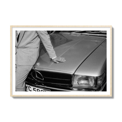 Fine art black & white photograph of a well dressed man leaning on a vintage Mercedes. Archival pigment print, collector size, natural wood frame.