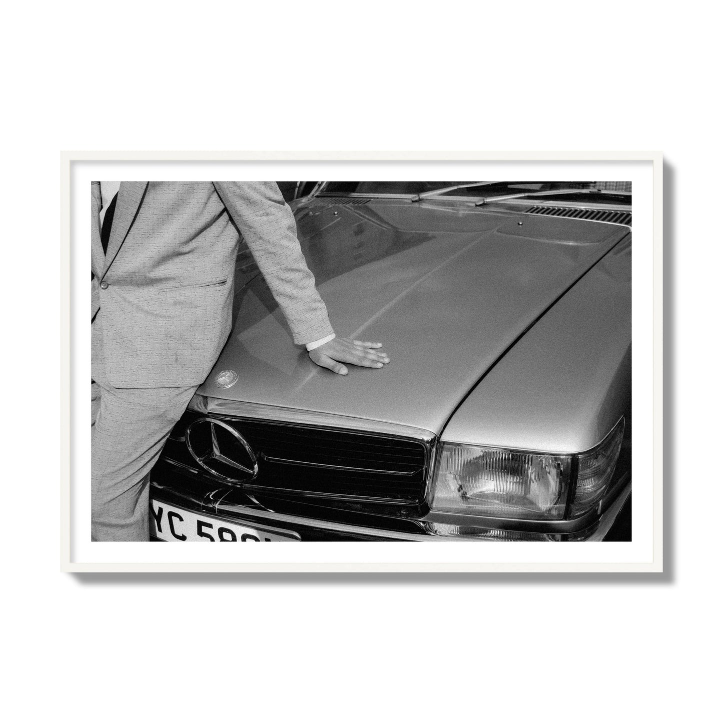 Fine art black & white photograph of a well dressed man leaning on a vintage Mercedes. Archival pigment print, collector size, white frame.