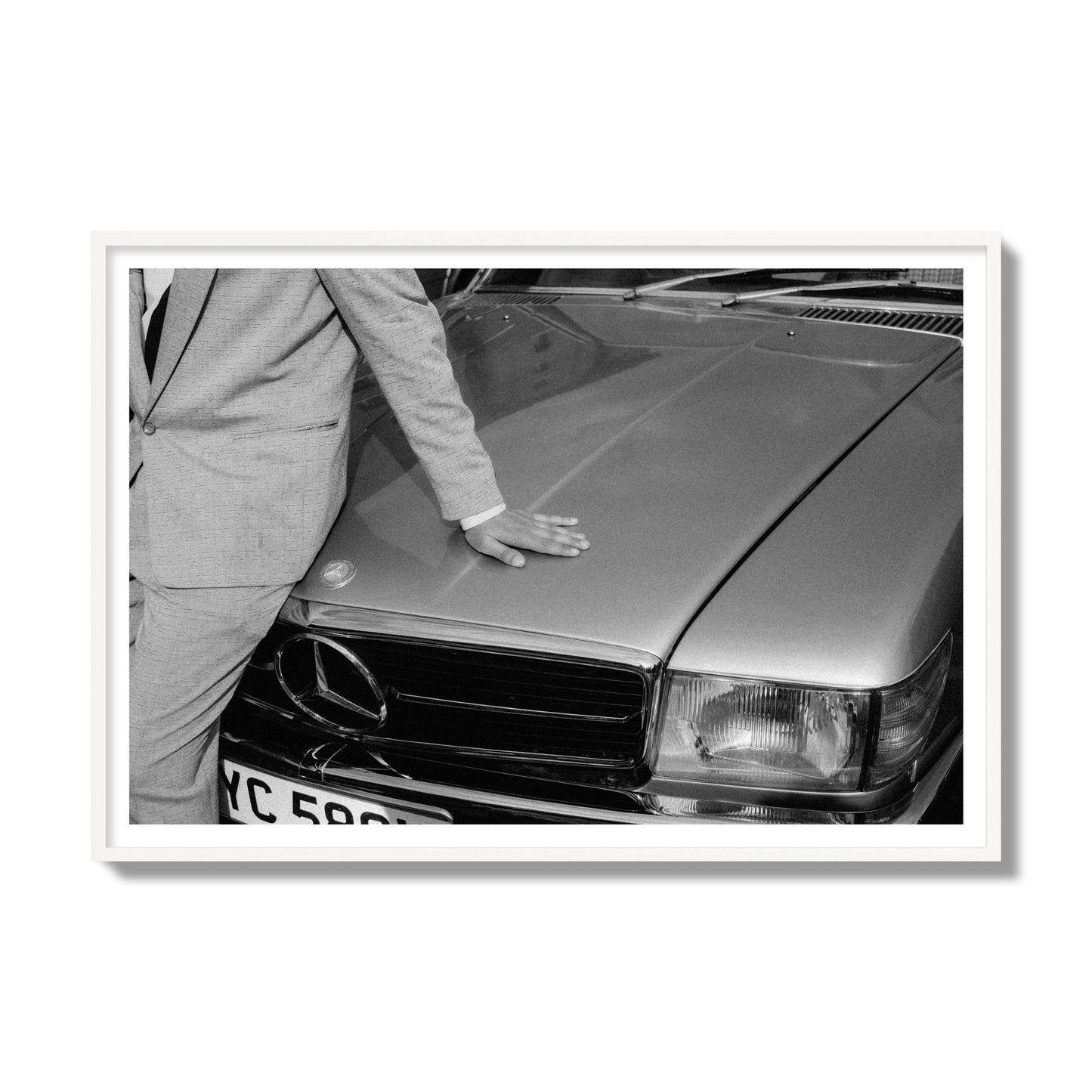 Fine art black & white photograph of a well dressed man leaning on a vintage Mercedes. Archival pigment print, gallery size, white frame.