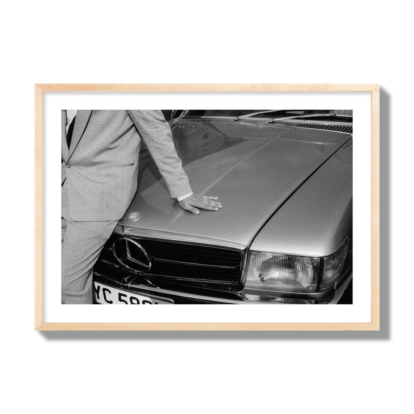 Fine art black & white photograph of a well dressed man leaning on a vintage Mercedes. Archival pigment print, giant size, natural wood frame.