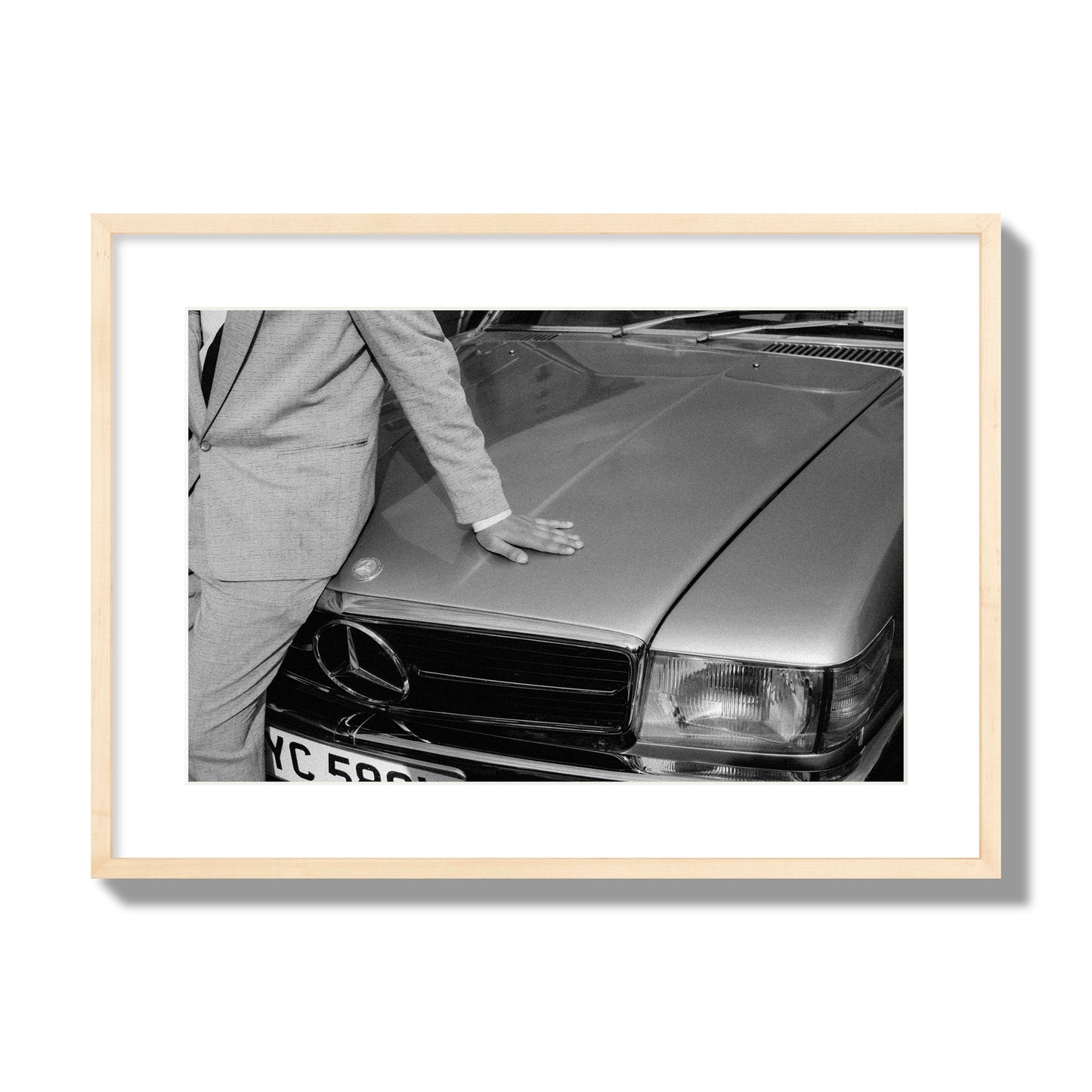 Fine art black & white photograph of a well dressed man leaning on a vintage Mercedes. Archival pigment print, large size, natural wood frame.