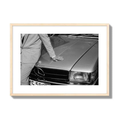 Fine art black & white photograph of a well dressed man leaning on a vintage Mercedes. Archival pigment print, large size, natural wood frame.
