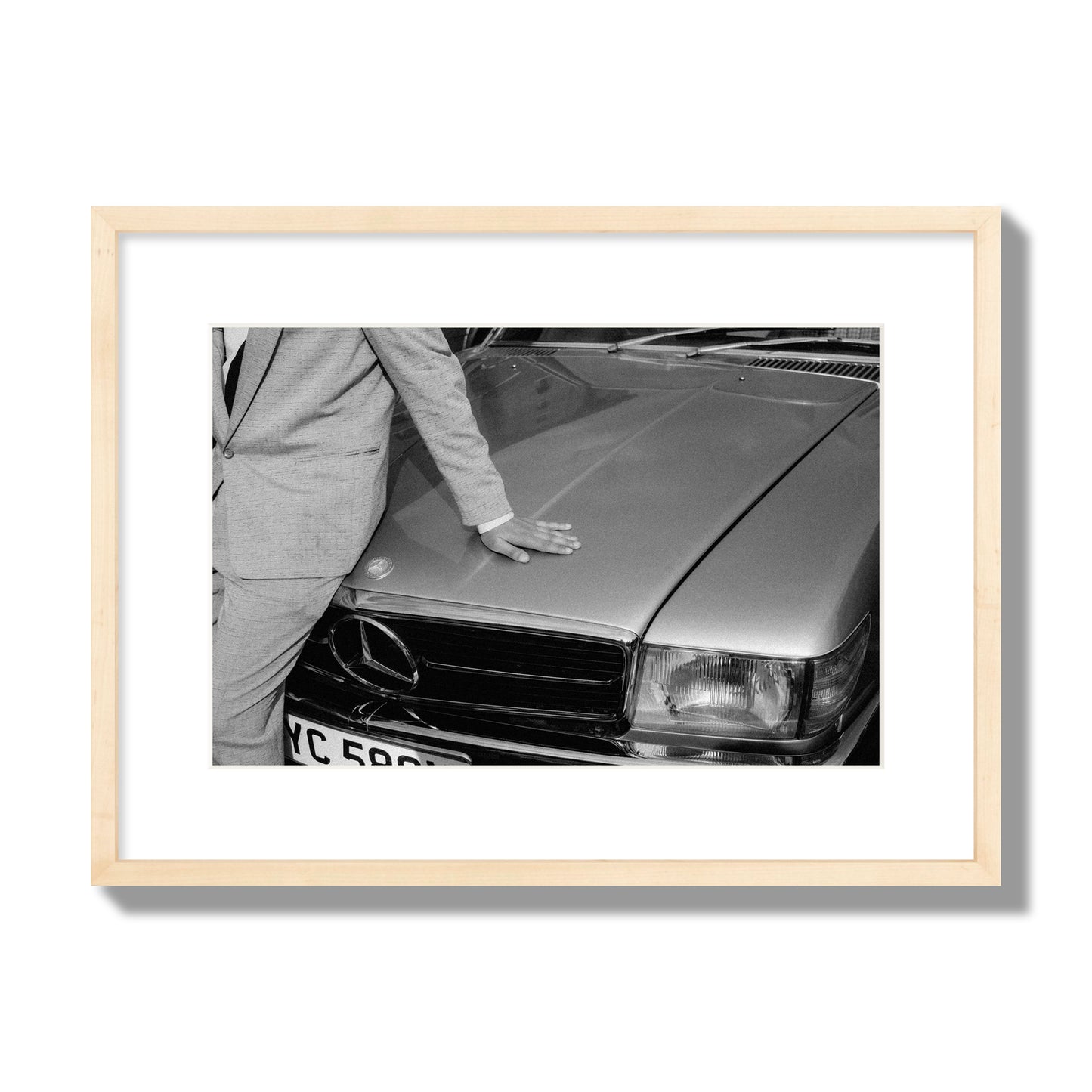 Fine art black & white photograph of a well dressed man leaning on a vintage Mercedes. Archival pigment print, medium size, natural wood frame.