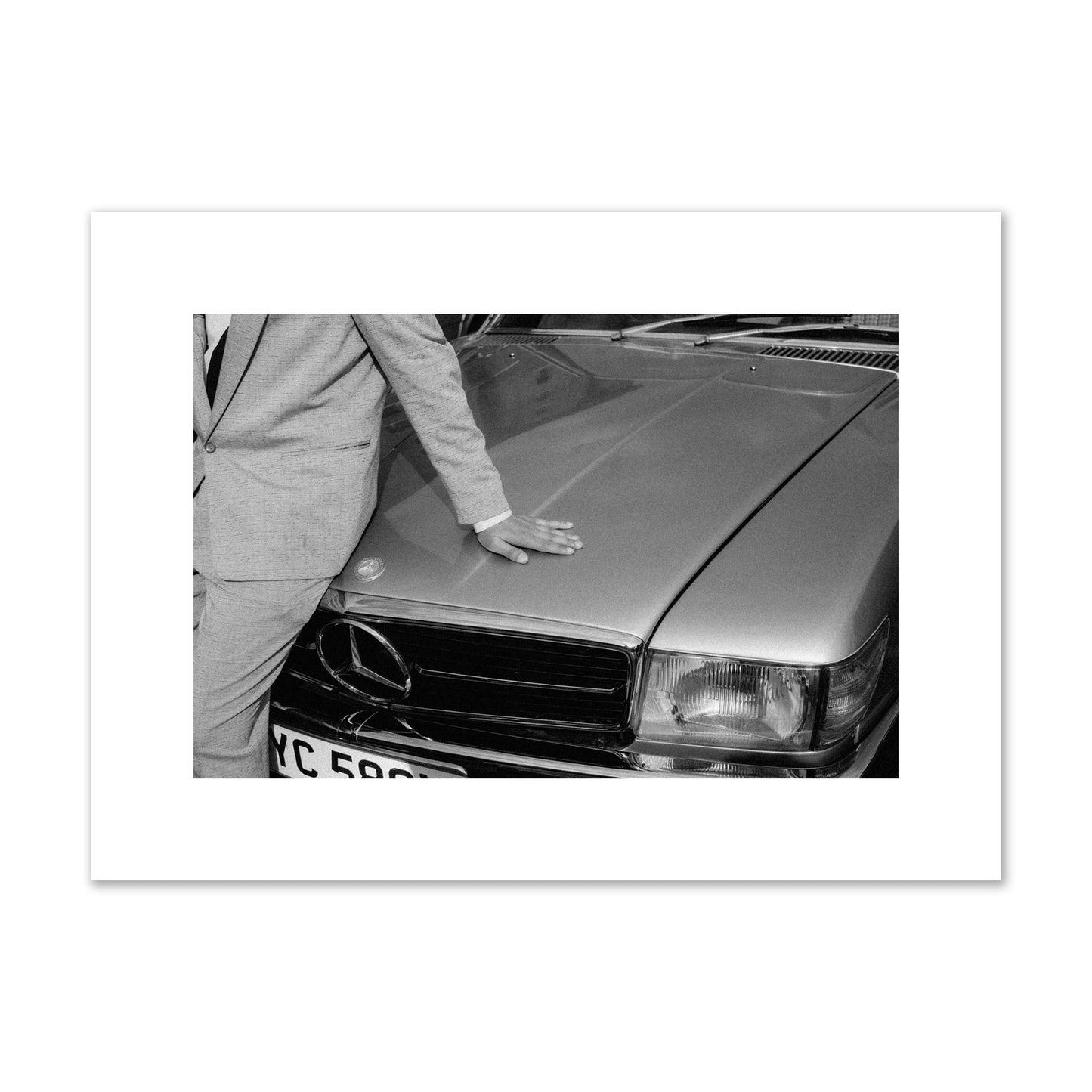 Fine art black & white photograph of a well dressed man leaning on a vintage Mercedes. Archival pigment print, medium size, print.