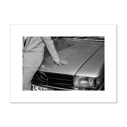 Fine art black & white photograph of a well dressed man leaning on a vintage Mercedes. Archival pigment print, medium size, print.