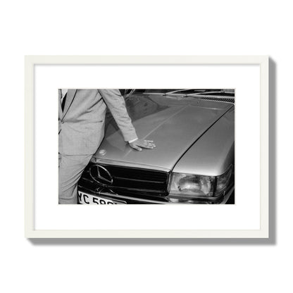Fine art black & white photograph of a well dressed man leaning on a vintage Mercedes. Archival pigment print, medium size, white frame.