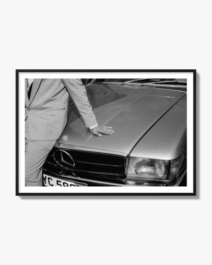 Fine art black & white photograph of a well dressed man leaning on a vintage Mercedes. Archival pigment print, black frame.