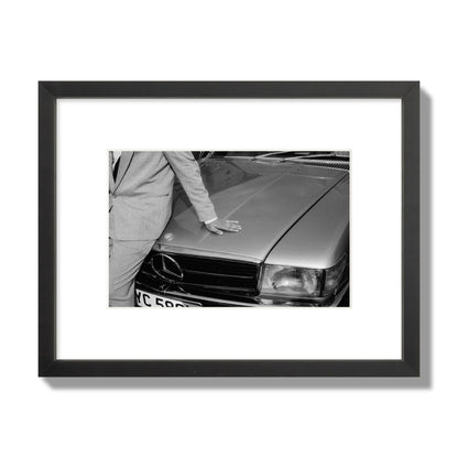 Fine art black & white photograph of a well dressed man leaning on a vintage Mercedes. Archival pigment print, small size, black frame.
