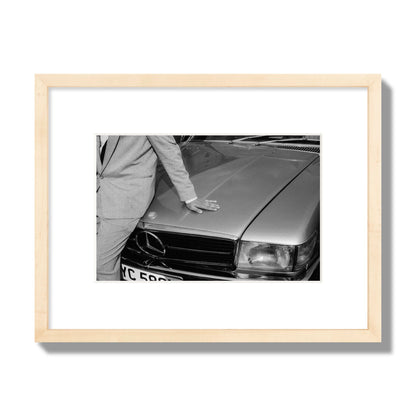 Fine art black & white photograph of a well dressed man leaning on a vintage Mercedes. Archival pigment print, small size, natural wood frame.