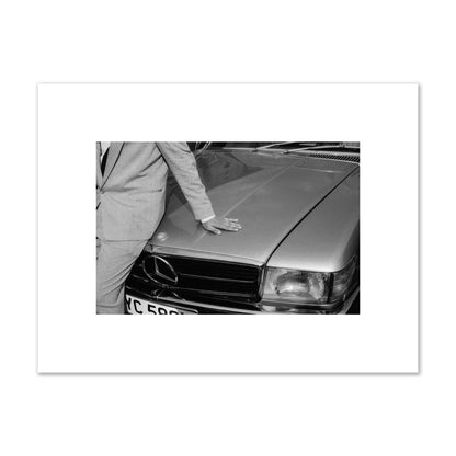 Fine art black & white photograph of a well dressed man leaning on a vintage Mercedes. Archival pigment print, small size, print.