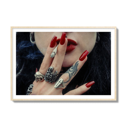Fine art close-up photograph of a woman smoking, her hands covered with chunky rings and tattoos. Archival pigment print, collector size, natural wood frame.