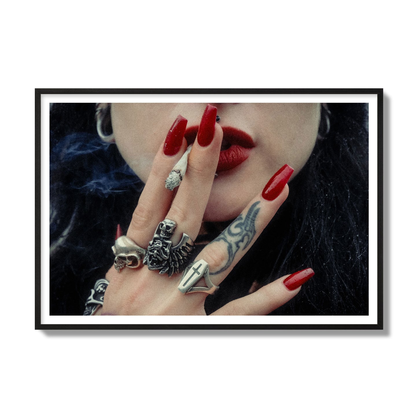 Fine art close-up photograph of a woman smoking, her hands covered with chunky rings and tattoos. Archival pigment print, gallery size, black frame.