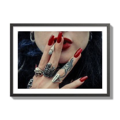 Fine art close-up photograph of a woman smoking, her hands covered with chunky rings and tattoos. Archival pigment print, giant size, black frame.